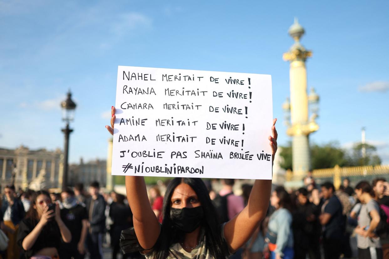 A protester holds a placard with names of victims with the quote 