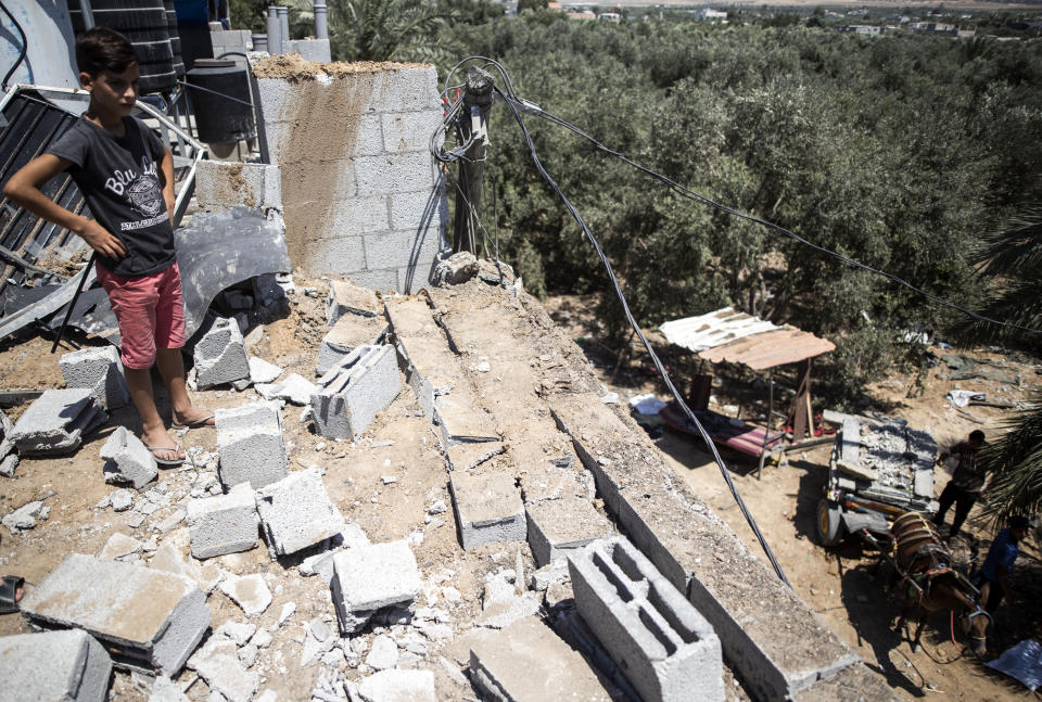 A Palestinian boy inspects the damage in his family home following Israeli airstrikes in Buriej refugee camp, central Gaza Strip, Saturday, Aug. 15, 2020. (AP Photo/Khalil Hamra)