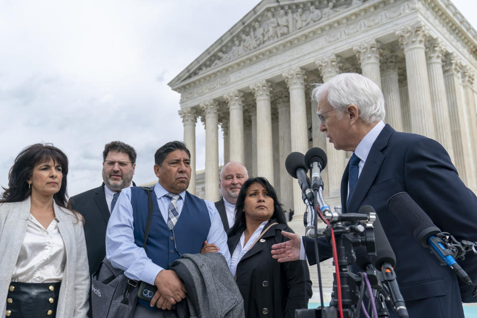 Attorney Eric Schnapper, right, gestures to Beatriz Gonzalez, second from right, the mother of 23-year-old Nohemi Gonzalez, a student killed in the Paris terrorist attacks, and stepfather Jose Hernandez, front row center, speak outside the Supreme Court,Tuesday, Feb. 21, 2023, in Washington. A lawsuit against YouTube from the family of Nohemi Gonzalez was argued at the Supreme Court. (AP Photo/Alex Brandon)