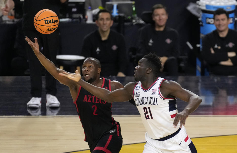 San Diego State guard Adam Seiko (2) and Connecticut forward Adama Sanogo (21) reach for a rebound during the first half of the men's national championship college basketball game in the NCAA Tournament on Monday, April 3, 2023, in Houston. (AP Photo/Godofredo A. Vasquez)