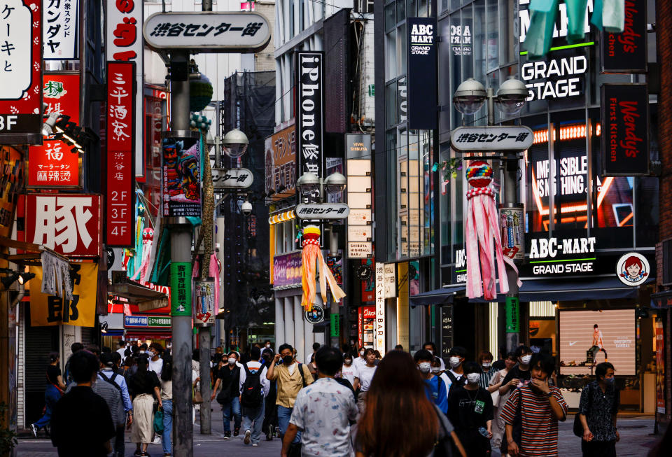 Passers-by wearing protective masks walk the street in the Shibuya shopping and entertainment district amid the coronavirus disease (COVID-19) pandemic, in Tokyo, Japan, July 28, 2022. REUTERS / Issei Kato