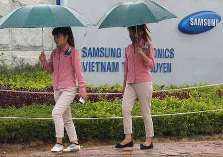 An employee (L) holds a smartphone as she is on the way to work at the Samsung factory in Thai Nguyen province, north of Hanoi, Vietnam October 13, 2016. REUTERS/Kham