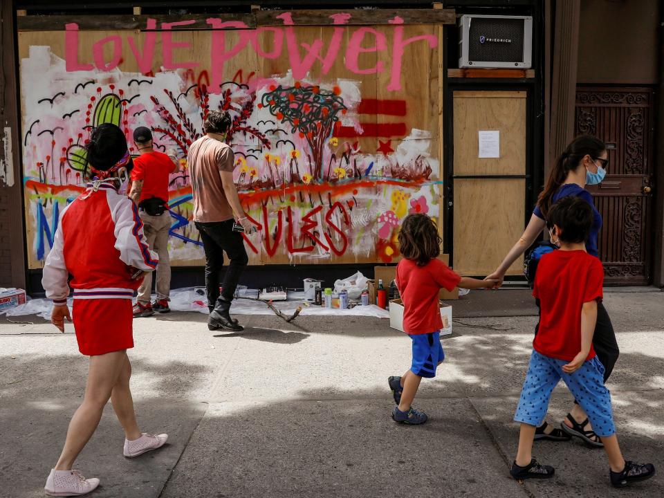 Artists paint a mural on a boarded-up storefront as part of neighborhood project in the Bowery neighborhood of Manhattan in New York City, New York, U.S., June 17, 2020. Picture taken June 17, 2020.