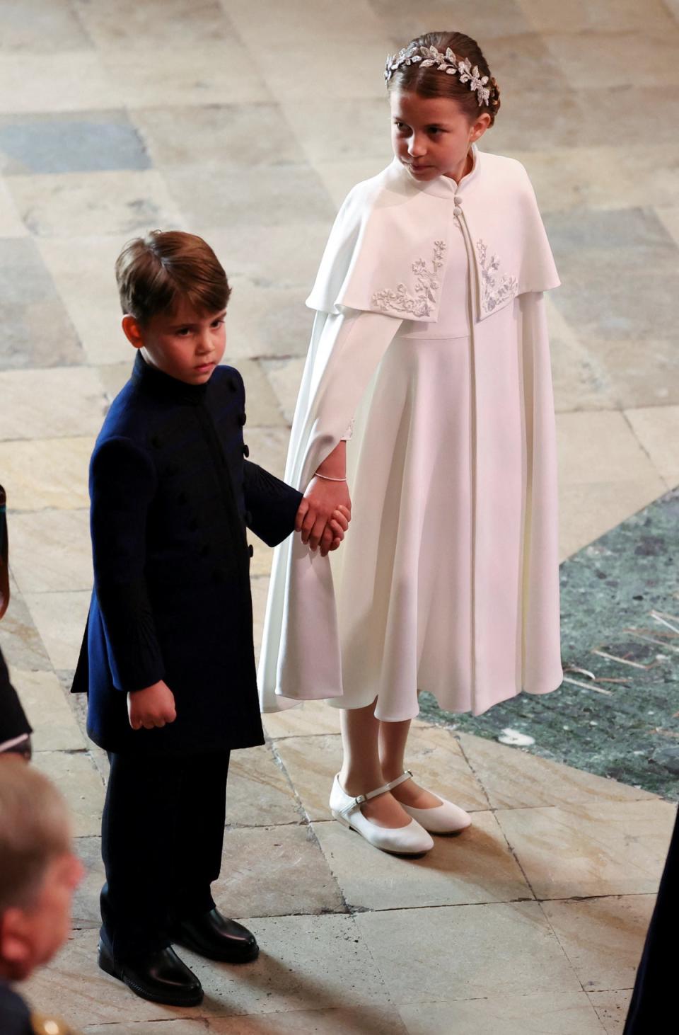 Louis and Charlotte hold hands ahead of the coronation ceremony (Reuters)