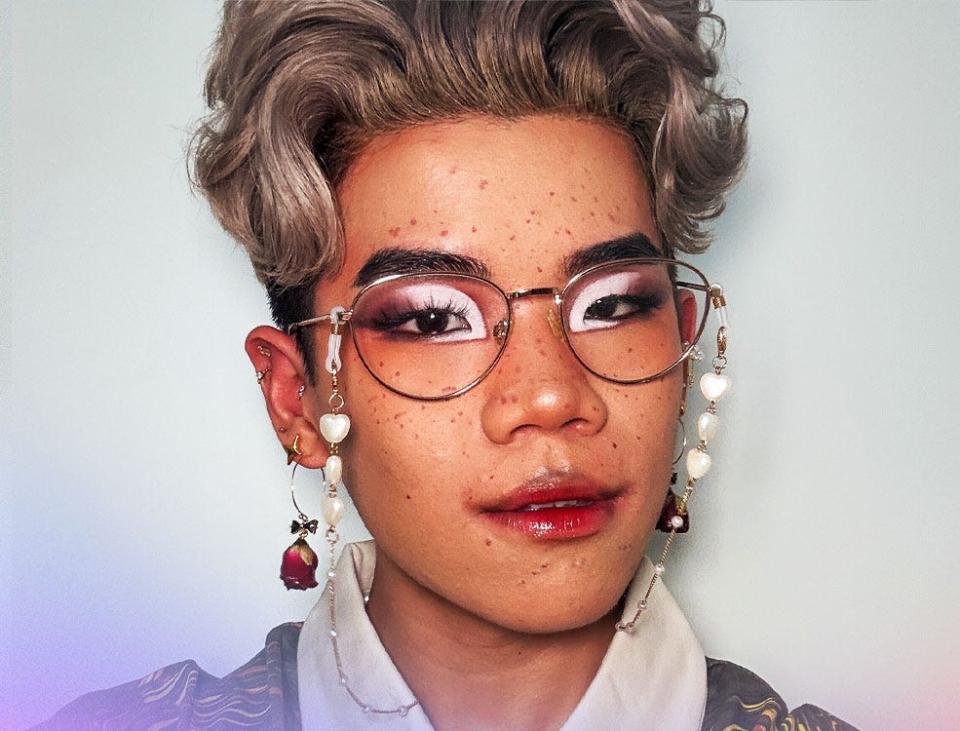 close up pic of person wearing makeup and glasses with short grey hair