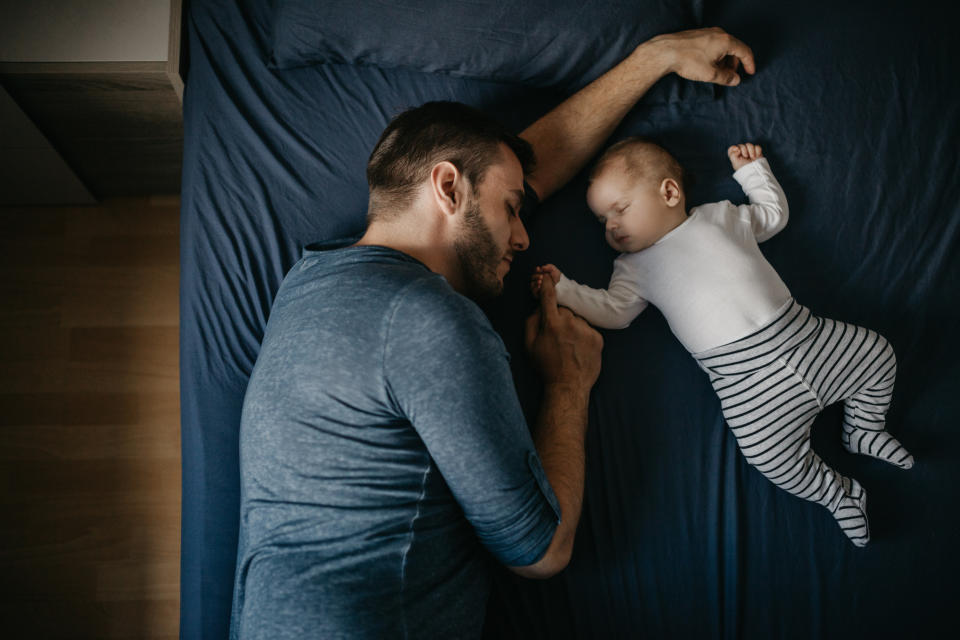 Dad sleeping with baby. (Getty Images)