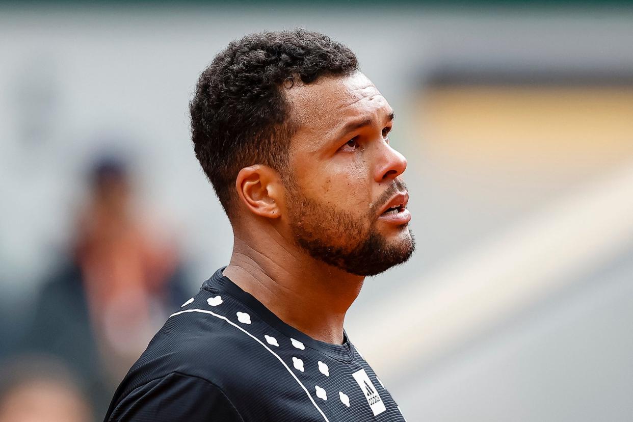 Jo-Wilfried Tsonga of France cries as him retires during his match against Casper Ruud of Norway during the 2022 French Open at Roland Garros