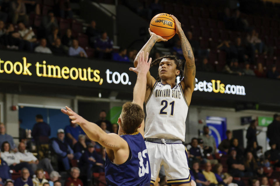 Montana State guard RaeQuan Battle (21 puts up a shot over Northern Arizona forward Carson Towt (33) in the first half of an NCAA college basketball game for the championship of the Big Sky men's tournament in Boise, Idaho, Wednesday, March 8, 2023. (AP Photo/Steve Conner)