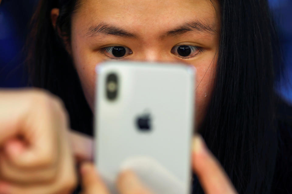 A customer is shown a new iPhone X at an Apple Store in Beijing, China. REUTERS/Damir Sagolj