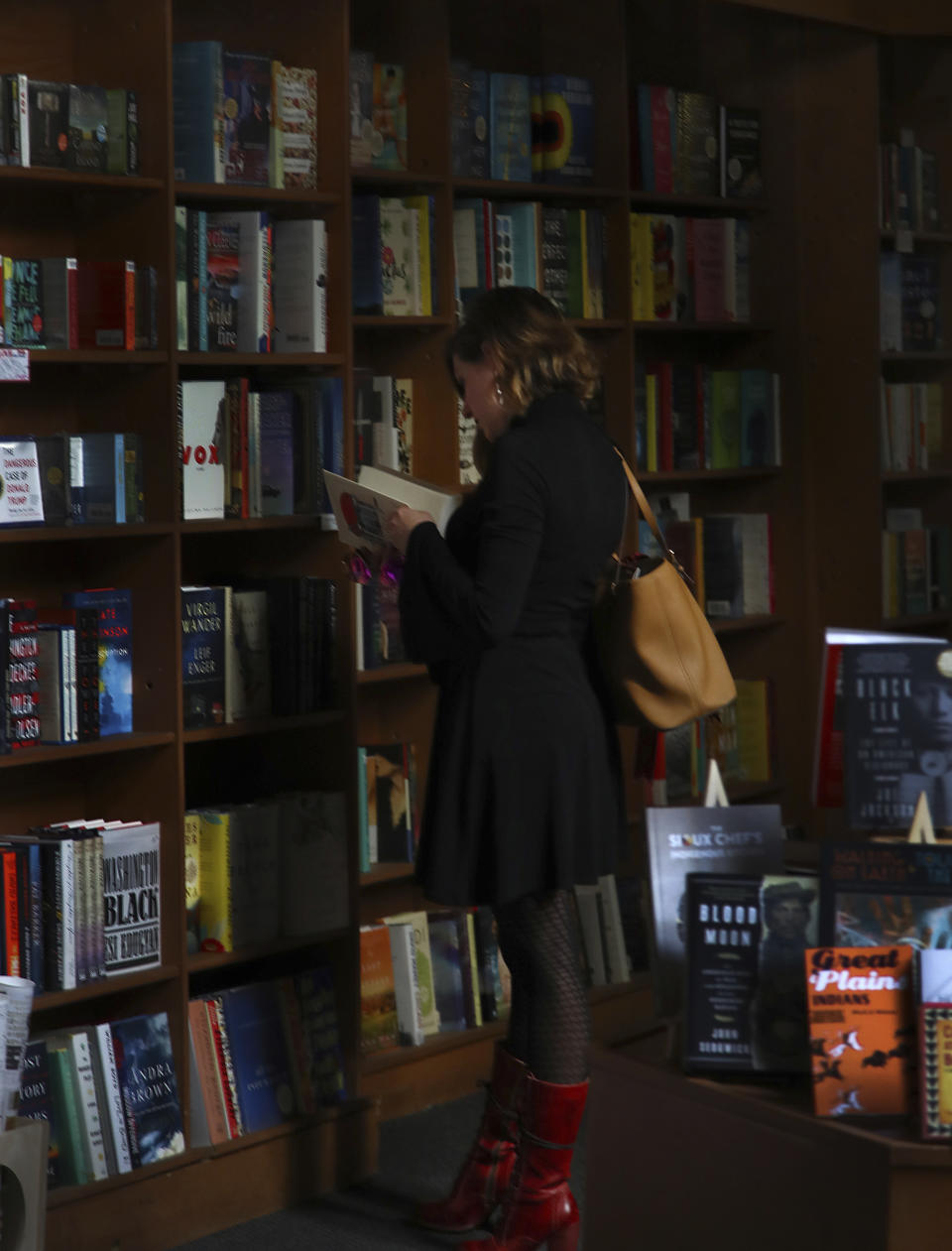 A Copperfield's Bookstore customer reads a book via a skylight on Monday, Oct. 15, 2018, in Calistoga, Calif. Northern California's biggest utility has taken the unprecedented step of cutting electricity for tens of thousands of customers in an attempt to prevent wildfires amid rising winds and official warnings on Monday of extreme fire danger. (AP Photo/Ben Margot)