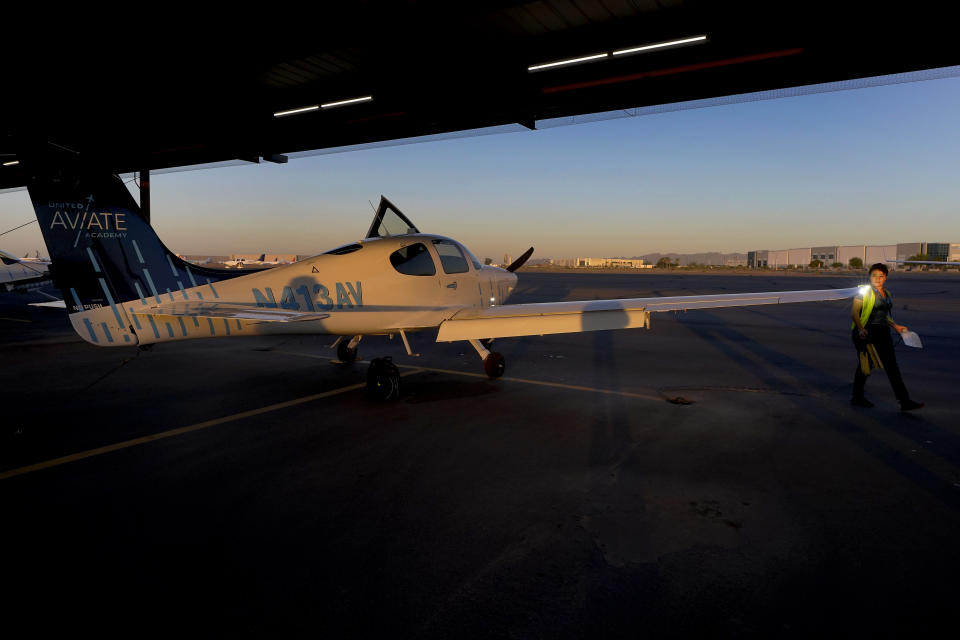 United Aviate Academy student pilot Ashley Montano inspects her aircraft prior to a flight, Friday, Oct. 28, 2022, in Goodyear, Ariz. Montano hopes that in a few years she will be flying airline jets. If she does, she'll be helping solve a critical problem facing the industry: not enough pilots. (AP Photo/Matt York)