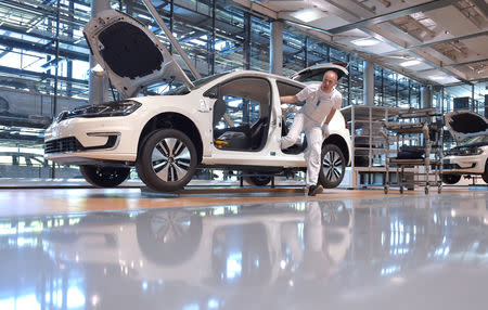 FILE PHOTO: Mechanic staff work on the production line of Volkswagen e-Golf in the Glaeserne Manufaktur plant in Dresden, Germany May 8, 2018. REUTERS/Matthias Rietschel/File Photo