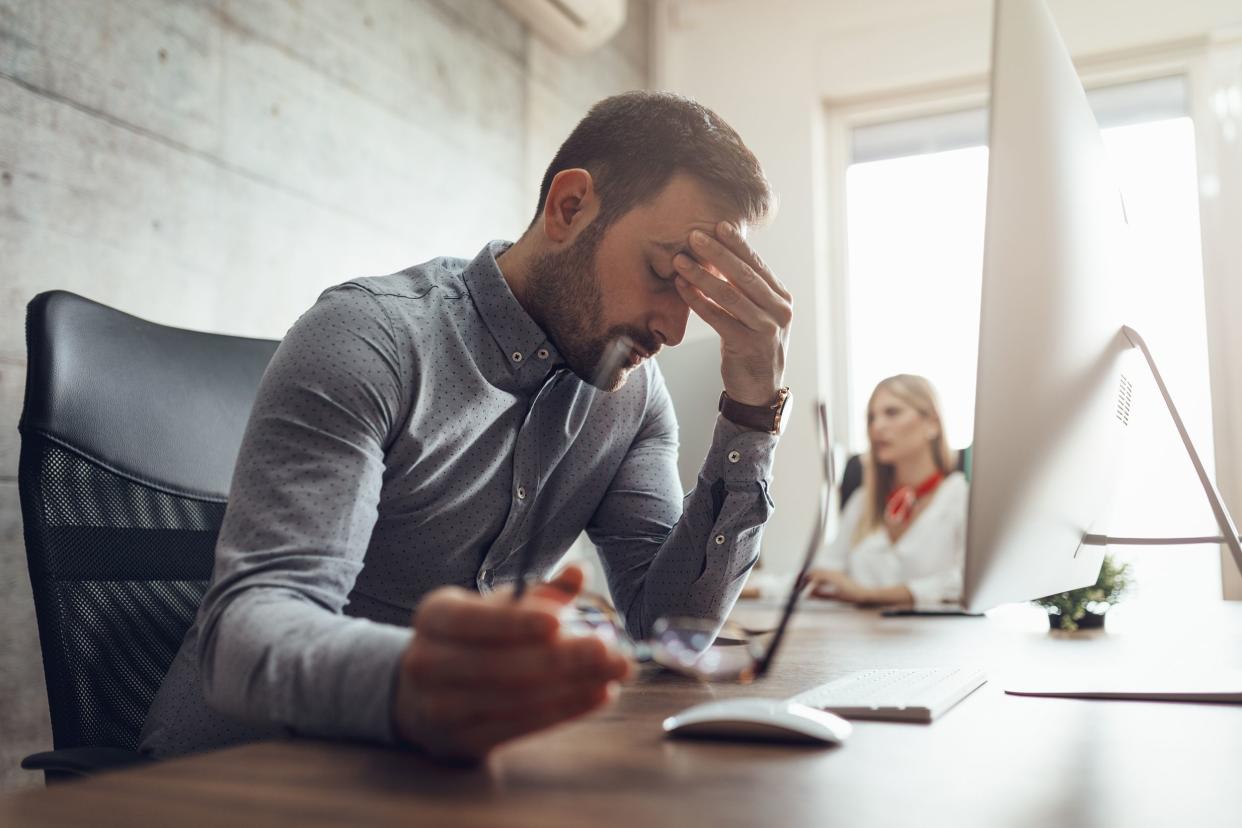 exhausted man working at desk in office