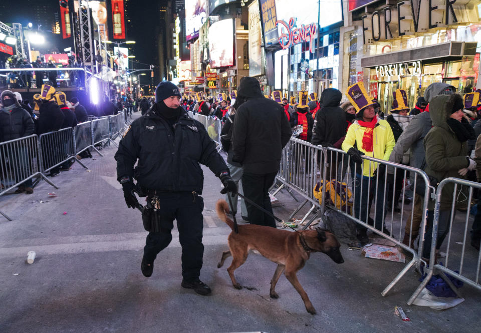 <p>A New York City canine police officer walks past revelers gathered on Times Square in New York Sunday, Dec. 31, 2017, during a New Year’s Eve celebration. (Photo: Craig Ruttle/AP) </p>