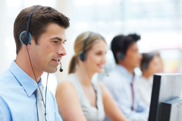 Cropped shot of telecommunications workers sitting at their desks