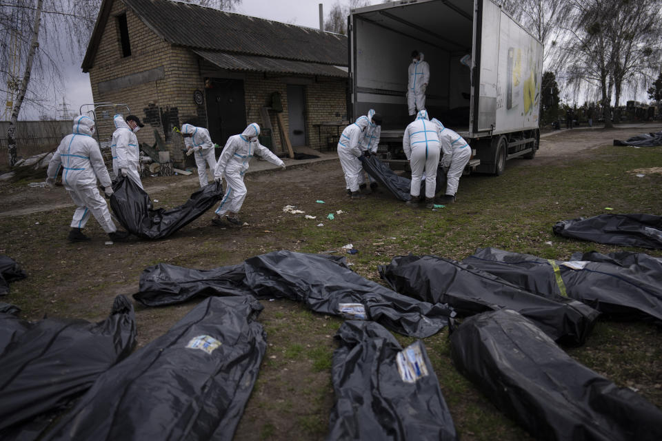 ARCHIVO - Voluntarios suben cuerpos de civiles asesinados en la localidad de Bucha a un camión con el fin de que sean llevados a la morgue para que se les realicen autopsias, el martes 12 de abril de 2022, en las afueras de Kiev, Ucrania. (AP Foto/Rodrigo Abd, archivo)