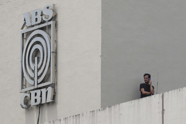 A man stands next to a logo at the headquarters of broadcast network ABS-CBN Corp. on Wednesday May 6, 2020 in Manila, Philippines. Philippine church and business leaders expressed alarm Wednesday over a government agency’s shutdown of the country’s largest TV and radio network, which has been a major provider of news on the coronavirus pandemic. (AP Photo/Aaron Favila)