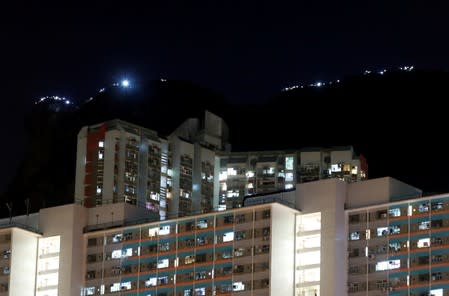 Protesters hold hands and light up their smartphones as they form a human chain during a rally to call for political reforms on top of the iconic Lion Rock in Hong Kong