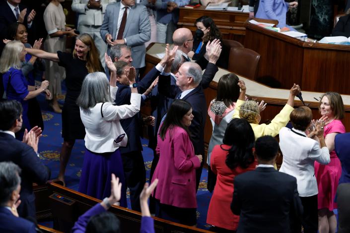 Democratic members of the House of Representatives embrace and give high-fives after the Inflation Reduction Act of 2022 passed 220-207 on the House floor at the U.S. Capitol on August 12, 2022 in Washington, DC.