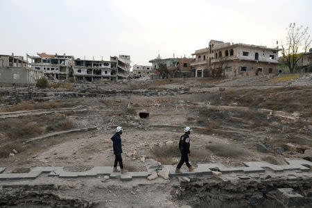 Members of Syria Civil Defence, also known as the 'White Helmets', are seen inspecting the damage at a Roman ruin site in Daraa, Syria December 23, 2017. REUTERS/Alaa al-Faqir/Files