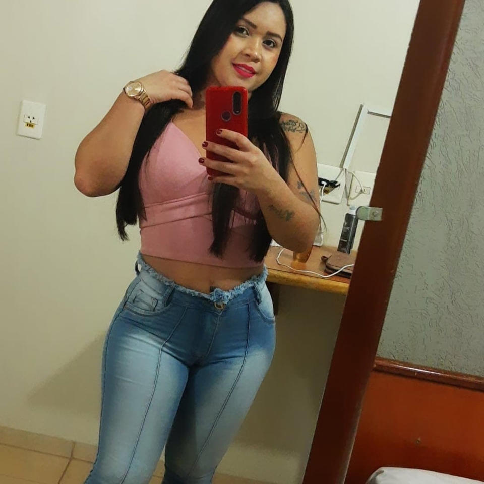 Claudia Cristina Menezes takes a selfie in a mirror. 