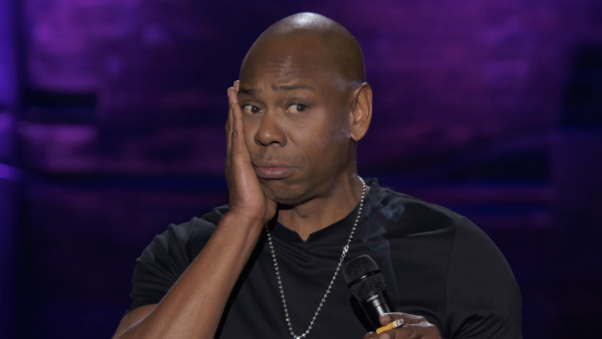  Dave Chappelle with hand on cheek in The Dream stand-up special. 