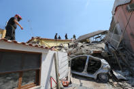 <p>Rescuers team walk near a house, destroyed in the earthquake in one of the more heavily damaged areas on Aug. 22, 2017 in Casamicciola Terme, Italy. (Photo: Marco Cantile/NurPhoto via Getty Images) </p>