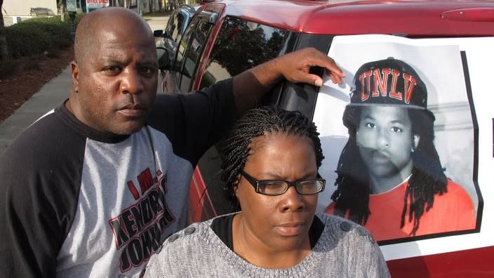 In this December 2013 photo, Kenneth and Jacquelyn Johnson stand next to a banner on their SUV showing their late son, Kendrick Johnson, in Valdosta, Ga. (Photo: AP)