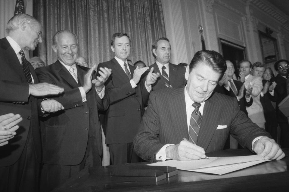 Then-President Ronald Reagan sits at a desk as he signs an extension of the 1965 Voting Rights Act in 1982.