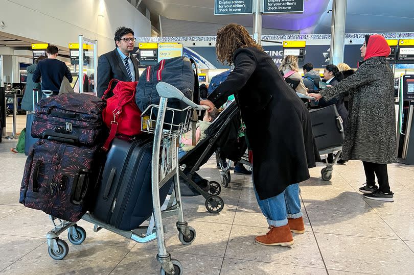 Woman pishing trolley with luggage