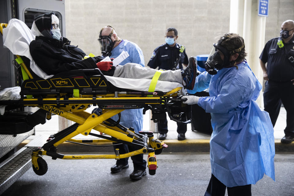 Paramedics load a person who has been staying overnight at Philadelphia International Airport into an ambulance in Philadelphia, Tuesday, May 26, 2020. Officials on Tuesday began removing dozens of people who have been sleeping at the city's airport during the coronavirus pandemic. (AP Photo/Matt Rourke)