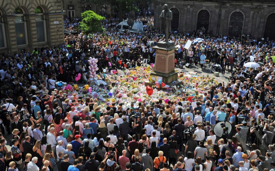 People attend a one minute silence to the victims of Monday's explosion at St Ann's Square in Manchester - Credit: Rui Vieira/ AP