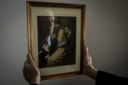 Alexander Sanger, Chair of the International Planned Parenthood Council, is reflected in a photograph of his Grandmother Margaret Sanger and her two sons Stuart Sanger and Grant Sanger (R) as he poses for a photo in the Manhattan borough of New York, December 12, 2015. Grant Sanger is Alexander's father and Margaret Sanger was the founder of Planned Parenthood. REUTERS/Carlo Allegri