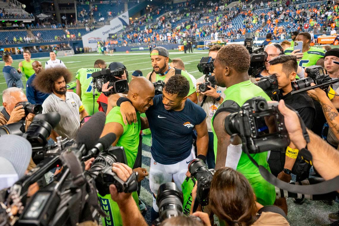 Denver Broncos quarterback Russell Wilson (3) hugs former teammate Seattle Seahawks wide receiver Tyler Lockett (16) after the game on Monday, Sept. 12, 2022, at Lumen Field in Seattle.