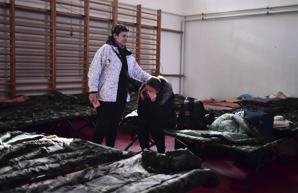 One woman comforts another in a temporary shelter set up for displaced persons fleeing Ukraine in Beregsurany, Hungary, Thursday, March 3, 2022. More than 1 million people have fled Ukraine following Russia's invasion in the swiftest refugee exodus in this century, the United Nations said Thursday. (AP Photo/Anna Szilagyi)