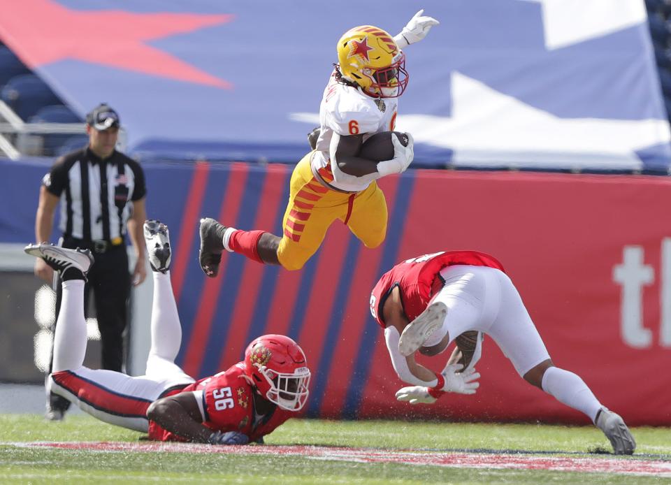 Philadelphia Stars running back Darnell Holland goes airborne to avoid the tackle of New Jersey Generals defenders Bryson Young, left, and Shalom Luani in the second half during their playoff game at Tom Benson Hall of Fame Stadium in June.