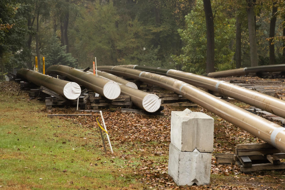 In this Tuesday, Oct. 22, 2019 photo, pipes lay along a construction site on the Mariner East pipeline in a residential neighborhood in Exton, Pa. The 350-mile (560-kilometer) pipeline route traverses those suburbs, close to schools, ballfields and senior care facilities. The spread of drilling, compressor stations and pipelines has changed neighborhoods — and opinions. (AP Photo/Matt Rourke)