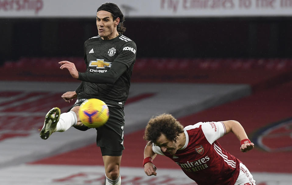 Arsenal's David Luiz, right, tries to block a shot from Manchester United's Edinson Cavani during the English Premier League soccer match between Arsenal and Manchester United at the Emirates stadium in London, Saturday, Jan. 30, 2021. (Andy Rain/Pool via AP)