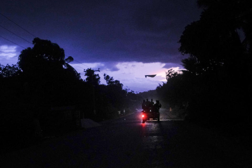 Commuters travel on a bus popularly referred to as "tap-tap" during a tropical storm in Miragoane, Haiti, Sunday, Aug. 15, 2021. (AP Photo/Matias Delacroix)