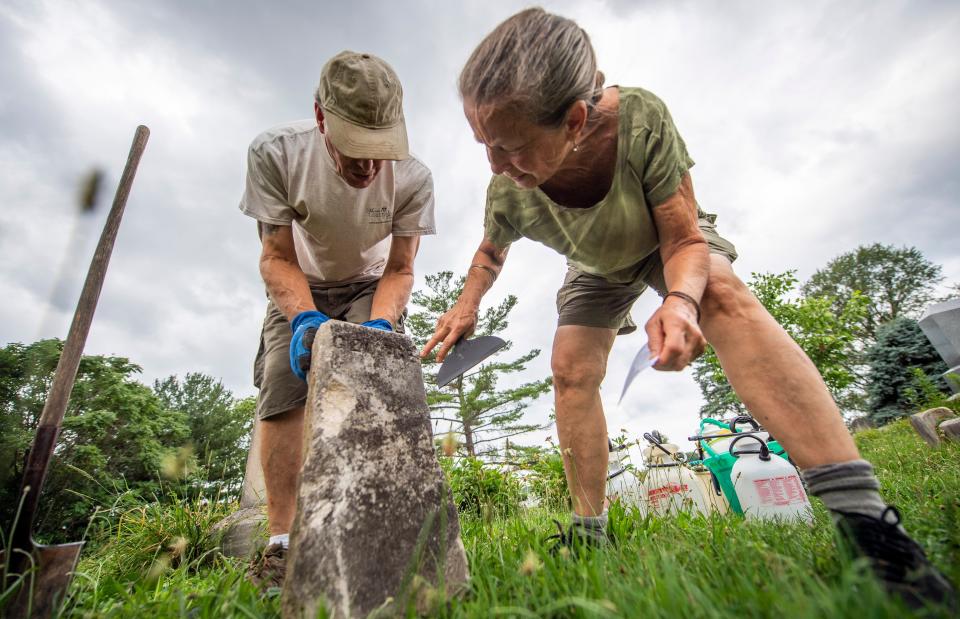 Scott Emery, left, and Cynthia Bretheim, right, examine a headstone during the headstone restoration workshop at Rose Hill Cemetery put on by Monroe County History Center Cemetery Committee and the Prospect Hill Neighborhood Association on Saturday, June 29, 2024.