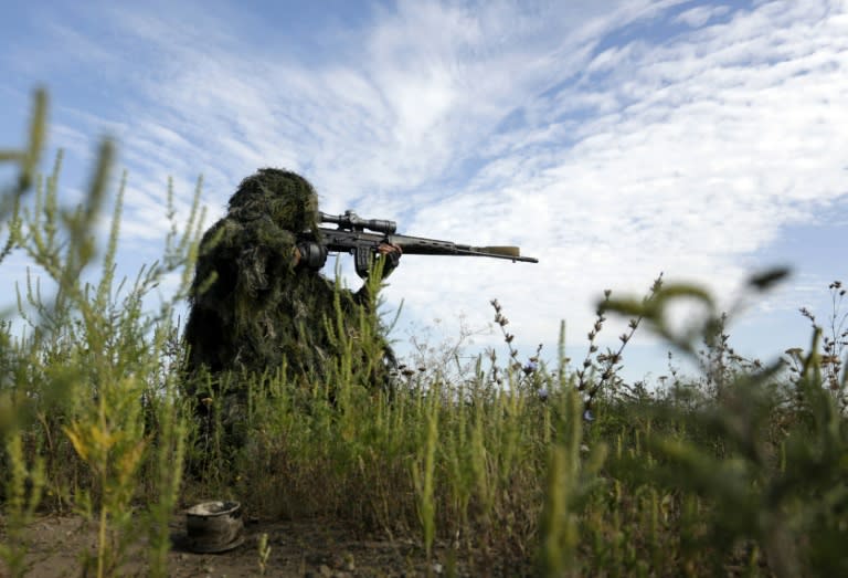 A Ukrainian sniper holds on the position of Ukrainian forces on frontline in the Lugansk region on August 27, 2015