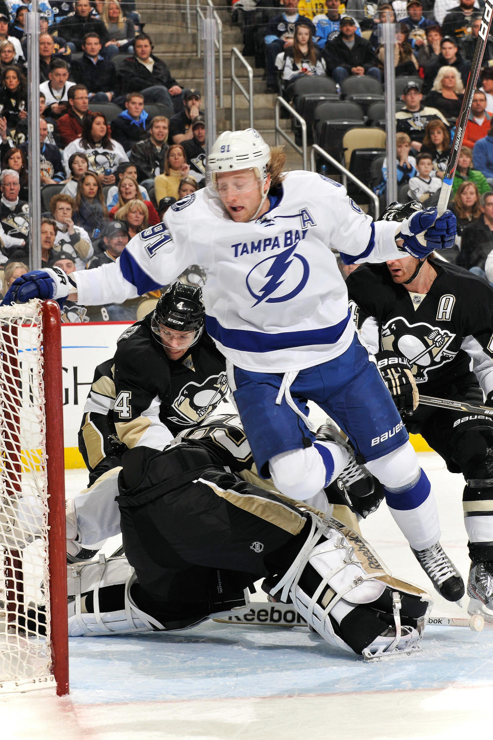 PITTSBURGH, PA - FEBRUARY 25: Steven Stamkos #91 of the Tampa Bay Lightning leaps over goaltender Marc-Andre Fleury #29 of the Pittsburgh Penguins to avoid a collision in the first period on February 25, 2012 at CONSOL Energy Center in Pittsburgh, Pennsylvania. (Photo by Jamie Sabau/Getty Images)