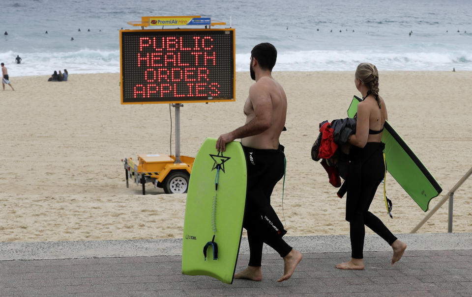 A sign warns people at a beach in Sydney, Australia, Saturday, Dec. 19, 2020. Sydney's northern beaches will enter a lockdown similar to the one imposed during the start of the COVID-19 pandemic in March as a cluster of cases in the area increased to more than 40. (AP Photo/Mark Baker)