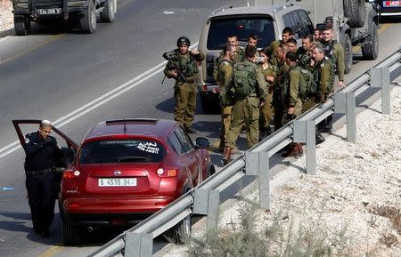 Israeli forces inspect the scene where Palestinian Sari Abu Ghrab was shot dead by Israeli troops near the West Bank village of Madama near Nablus August 24, 2016. REUTERS/Abed Omar Qusini