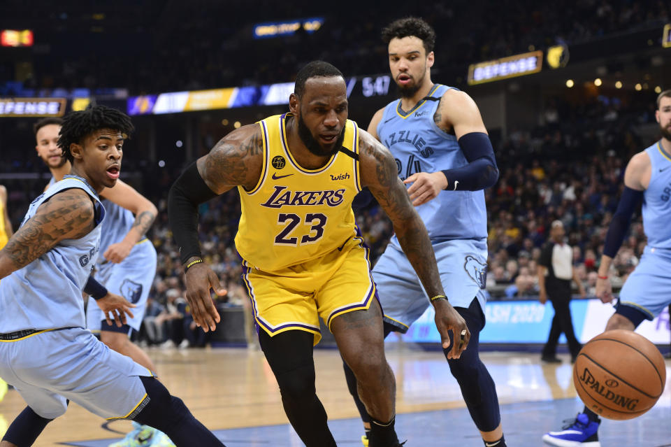 Los Angeles Lakers forward LeBron James (23) loses control of the ball between Memphis Grizzlies guards Ja Morant, left, and Dillon Brooks (24) in the second half of an NBA basketball game Saturday, Feb. 29, 2020, in Memphis, Tenn. (AP Photo/Brandon Dill)