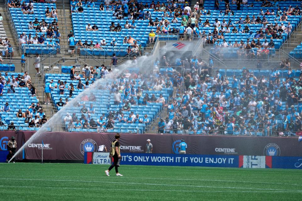 Charlotte FC fans get a little heat relief from the spray as the grounds crew waters the field before a game against the New York Red Bulls on Saturday, June 11.