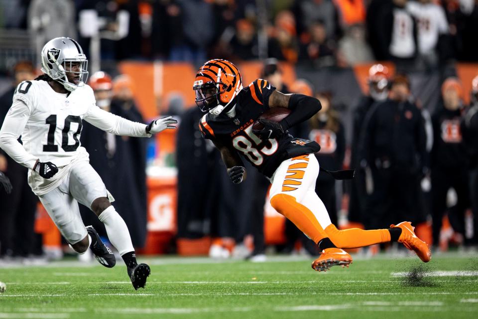 Cincinnati Bengals wide receiver Tee Higgins (85) runs downfield as Las Vegas Raiders cornerback Desmond Trufant (10) goes to tackle him after he got a first down in the second half the AFC wild card game on Saturday, Jan. 15, 2022, at Paul Brown Stadium in Cincinnati. Cincinnati Bengals defeated Las Vegas Raiders 26-19.