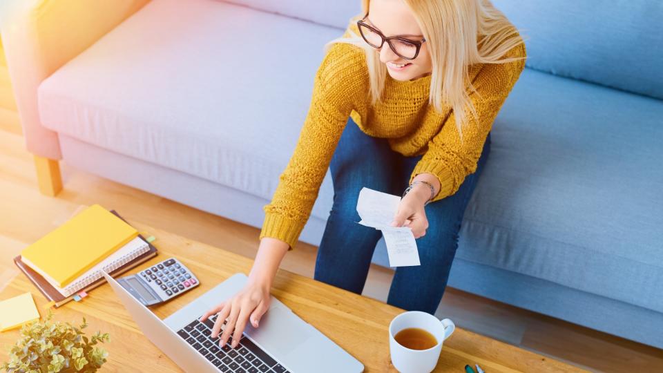 Woman doing bills on couch