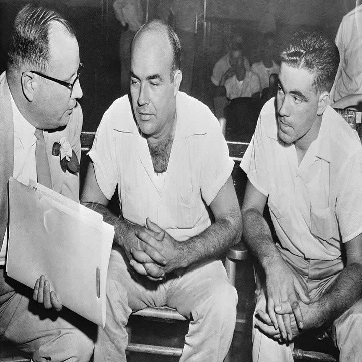 J.W. Milam (center) of Glendora, Miss., and his half brother, Roy Bryant (right) of Money, Miss., shown here conferring with an attorney