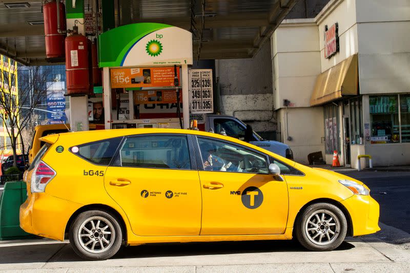 A cab driver wears plastic gloves after fueling his car in a gas station while gasoline price has been declined due to coronavirus disease (COVID-19) in New York